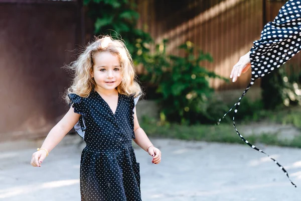 Kleines Mädchen mit lockigem Haar posiert vor der Kamera — Stockfoto