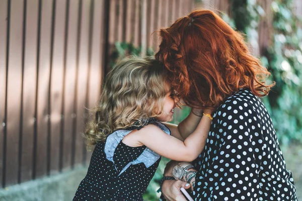 Ung mamma och hennes lilla dotter på staketet — Stockfoto