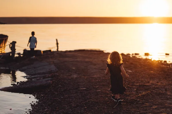 Dwoje dzieci spacer wzdłuż plaży, letni wieczór — Zdjęcie stockowe