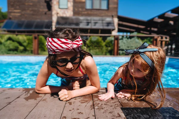 Deux petites filles sur le côté de la piscine — Photo