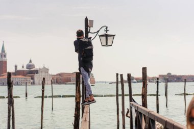 Genç adam bir Ahşap korkuluk üzerinde duruyor