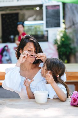 Anne ve kızı bir kafede oturuyor