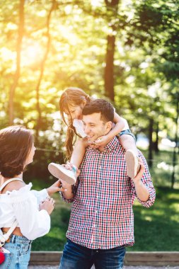 Parkta yürüyen mutlu bir aile.