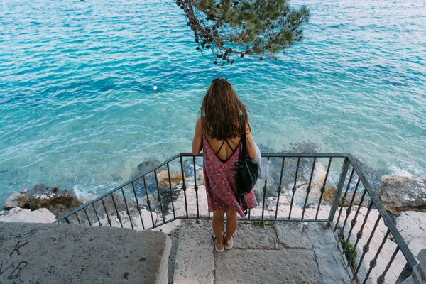 Uma linda menina junto ao mar tira uma foto — Fotografia de Stock