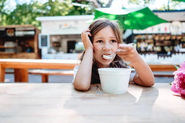 Menina comendo sorvete em um café — Fotografia de Stock