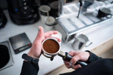 Barista holding portafilter with ground coffee clipart