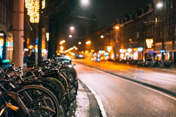 Bicicletas estacionadas ao longo da estrada, noite — Fotografia de Stock