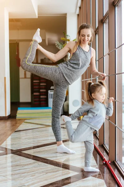 Mamá e hija juntas realizan diferentes ejercicios —  Fotos de Stock