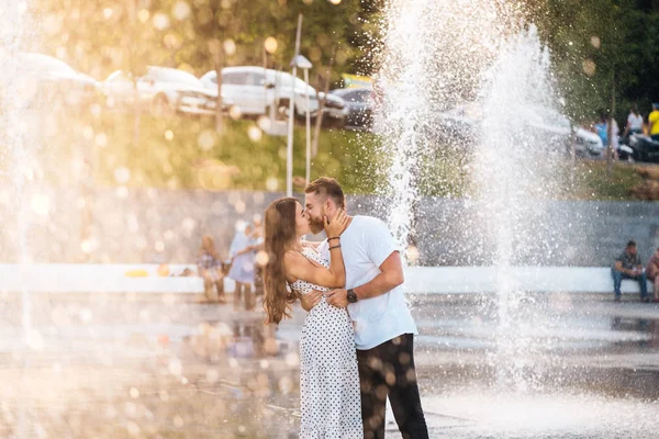 Красивий хлопець і красиві дівчата цілуються на фоні фонтану — стокове фото