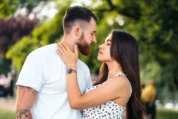 Schöner Kerl und schöne Mädchen küssen sich im Park — Stockfoto