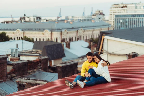 Kochająca młoda para siedzi na dachu domu.. — Zdjęcie stockowe