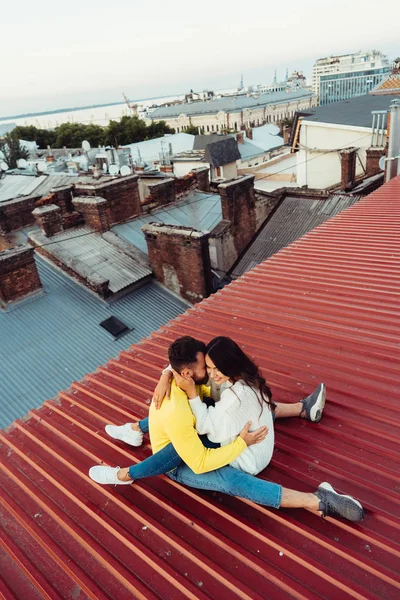 这对可爱的年轻夫妇正坐在房子的屋顶上. — 图库照片