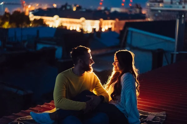 Любляча пара сидить на даху будинку. Прекрасний вечір — стокове фото