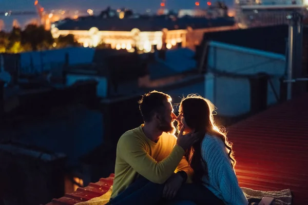 Casal amoroso está sentado no telhado da casa. Bela noite — Fotografia de Stock