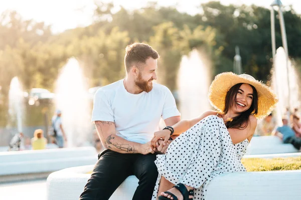 Handsome bearded man and his beautiful girl resting near fountains — Stock Photo, Image