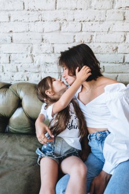 Annesi ve küçük kızı kanepede iyi eğlenceler.