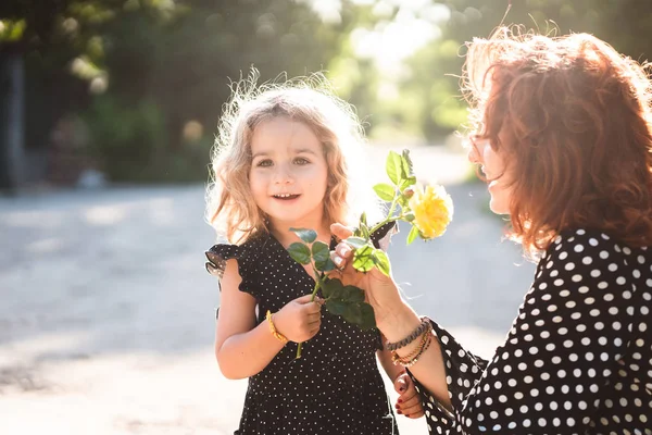 Mom and little daughter with a yellow rose — Stock Photo, Image