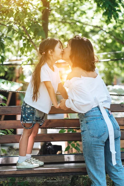 Ung mamma kramar hennes lilla flickan i parken — Stockfoto