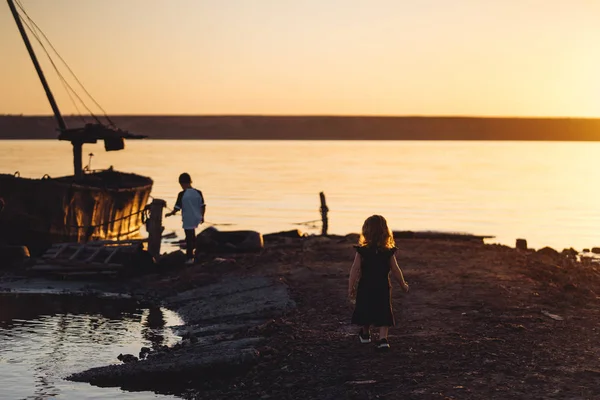 Duas crianças caminham ao longo da praia, noite de verão — Fotografia de Stock