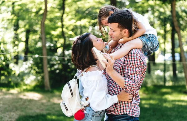 Joyeux jeune famille marchant dans le parc — Photo