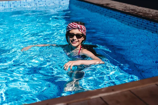 Beautiful teenage girl relaxing in pool water — Stock Photo, Image