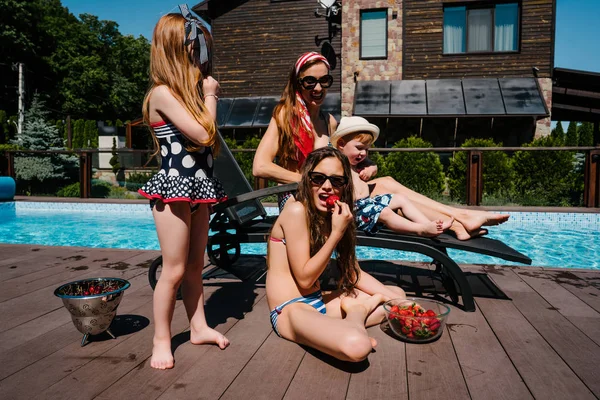 Una hermosa familia se está relajando junto a la piscina —  Fotos de Stock
