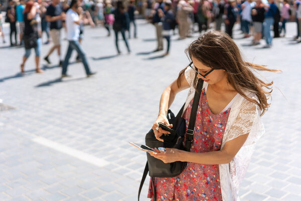красивая молодая девушка в платье и солнцезащитных очках читает сообщение
