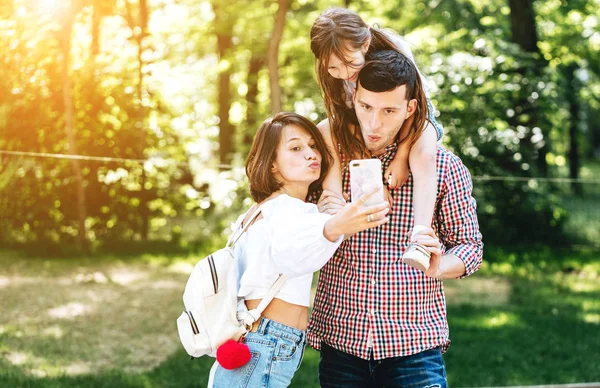 Mama Papa und kleine Tochter schauen aufs Smartphone — Stockfoto