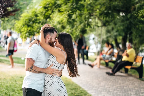 Schöner Kerl und junges Mädchen umarmen sich im Park. — Stockfoto