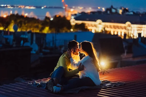 Loving couple is sitting on the roof of the house. Beautiful evening — Stock Photo, Image