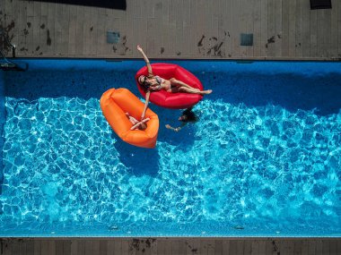 Anne ve kızı havuzu üzerinde dinlenme.