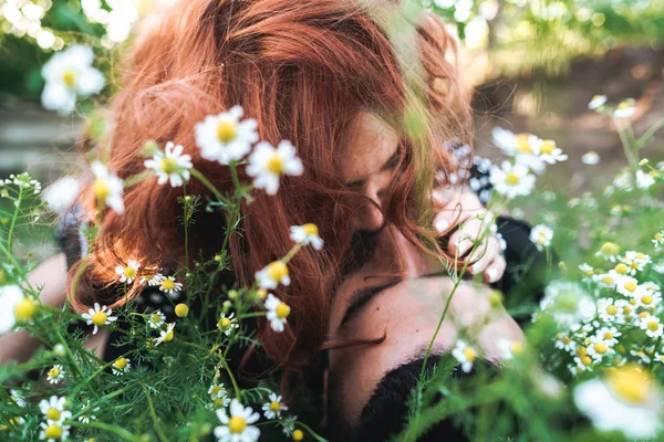 Casal jovem encontra-se no campo com margaridas . — Fotografia de Stock