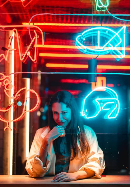 Menina bonita em um café da janela e olha para a câmera — Fotografia de Stock