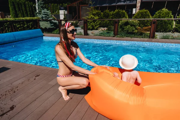 Belleza madre con littel hijo junto a la piscina —  Fotos de Stock