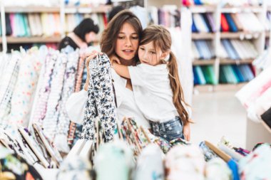 Anne ve kızı kumaş deposunda kumaş seçin