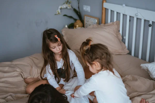 Mom and her two little cute daughters are having fun — Stock Photo, Image