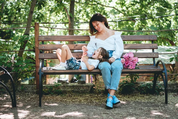 Mom feeds her little daughter ice cream in the park — Stock Photo, Image