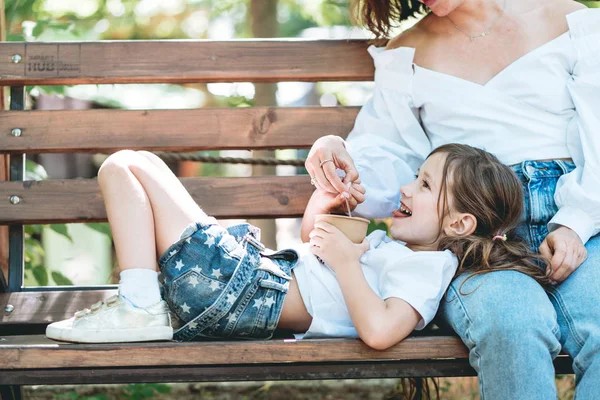 Μαμά τροφοδοτεί την μικρή κόρη παγωτό στο πάρκο — Φωτογραφία Αρχείου