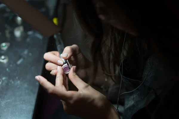 Девушка мастер обрабатывает металлическую пластину в домашней мастерской — стоковое фото