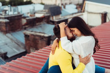 Sevgili genç çift evin çatısında oturuyor..