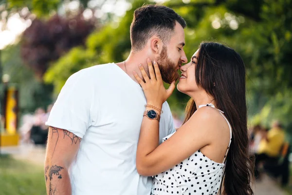 Handsome guy and beautiful girls kissing in the park — Stock Photo, Image