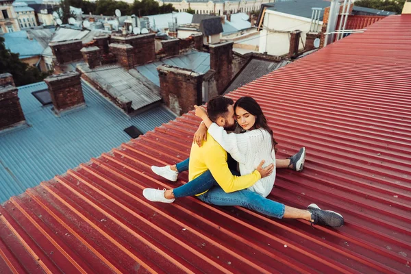 Любимая молодая пара сидит на крыше дома. — стоковое фото