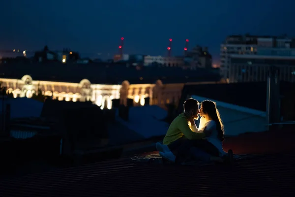 Le couple aimant est assis sur le toit de la maison. Belle soirée — Photo
