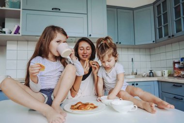 Anne ve iki kızı pankek yemek