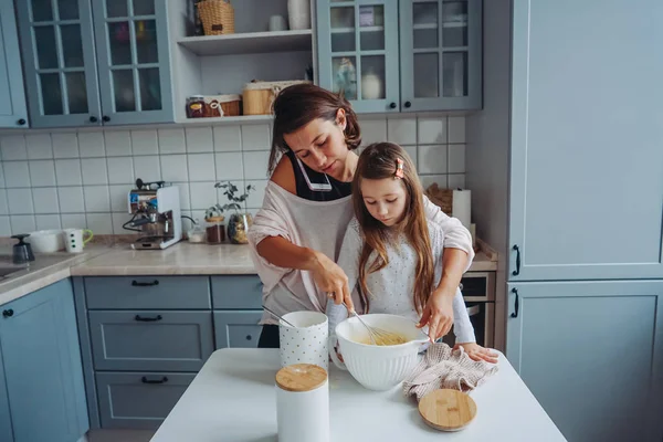 Мама учит свою маленькую дочь готовить еду — стоковое фото