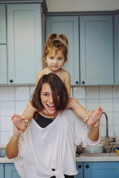 Krásný malý dcera piggybacking na ji šťastný matka — Stock fotografie