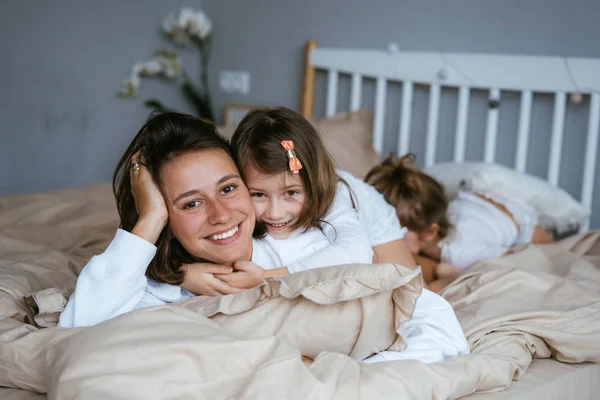 Mom and her two little cute daughters are having fun — Stock Photo, Image