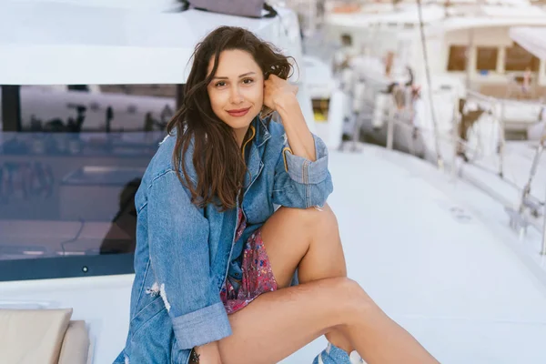 Młoda piękna dziewczyna siedzi na pokładzie jachtu — Zdjęcie stockowe
