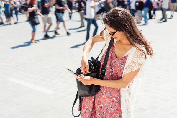 красивая молодая девушка в платье и солнцезащитных очках читает сообщение
