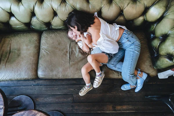 Η μαμά και το κοριτσάκι της να διασκεδάσουν στον καναπέ. — Φωτογραφία Αρχείου